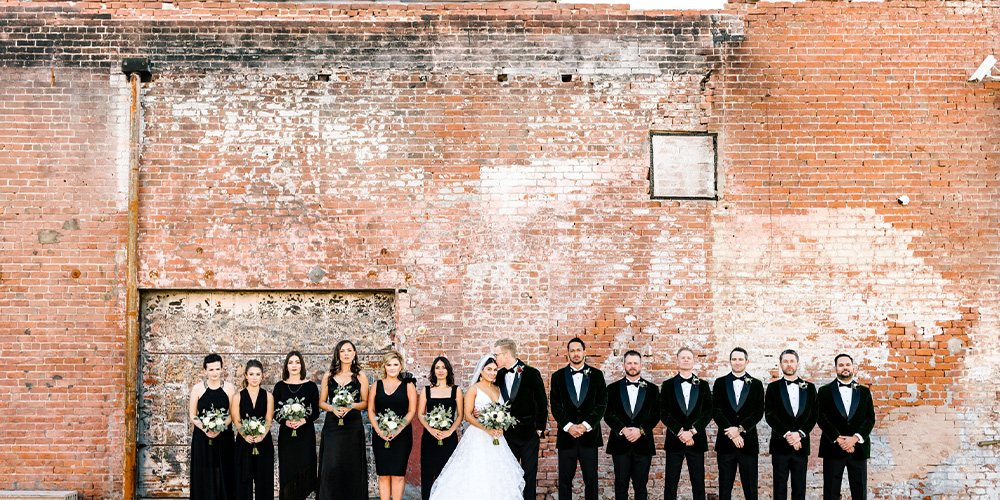 Wedding party in front of industrial brick wall in downtown Phoenix