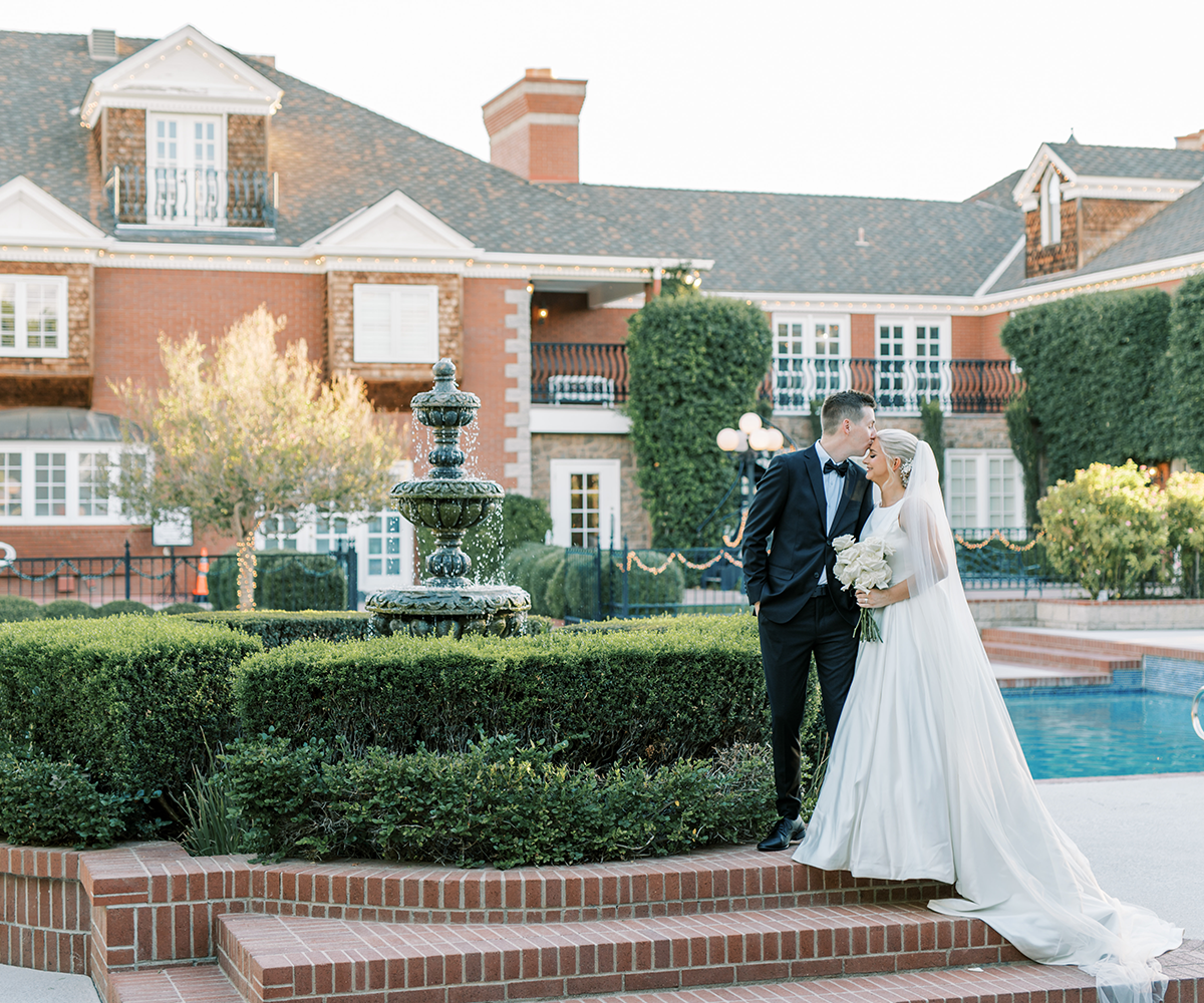 Bride and groom in front of fountain and pool, Stonebridge Manor