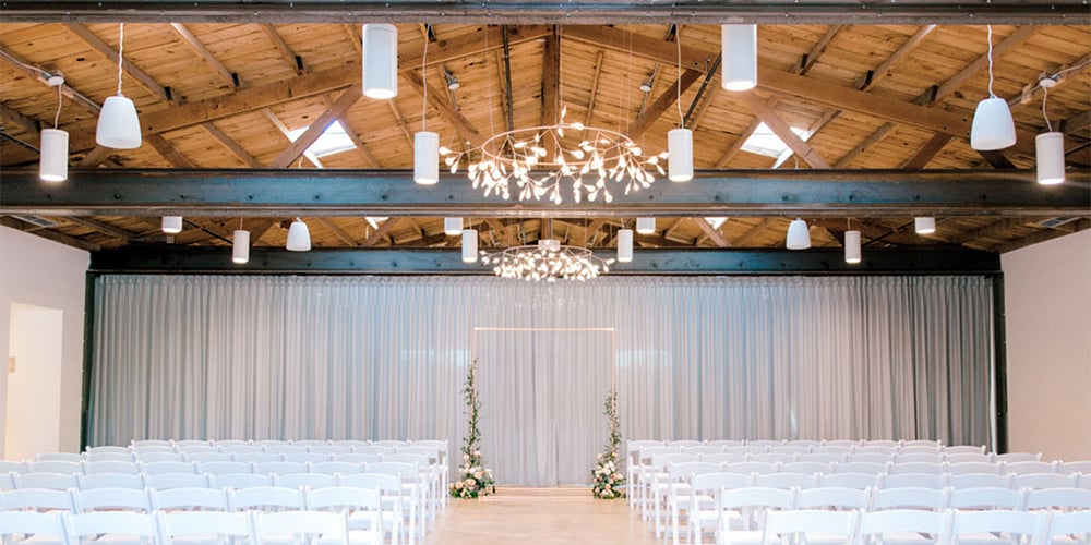 Ceremony site decor with elegant flower arch beautifully complimented by the industrial feel of Clayton House by Wedgewood Weddings