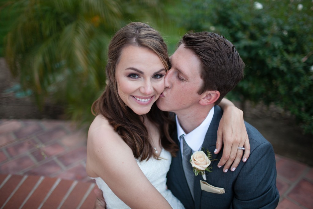 beautiful shot of bride and groom with groom kissing her cheek