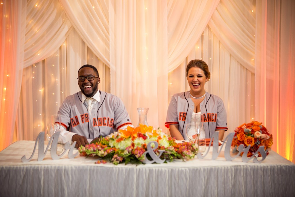 bride and groom at reception wearing their favorite sports team